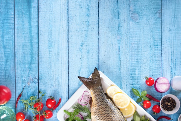 Pesce crudo fresco e gustoso servito su un vecchio tavolo di legno blu con ingredienti da cucina Vista dall'alto Spazio di copia