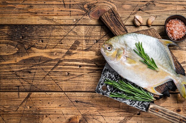 Pesce crudo Pesce luna o pompano su tavola di legno