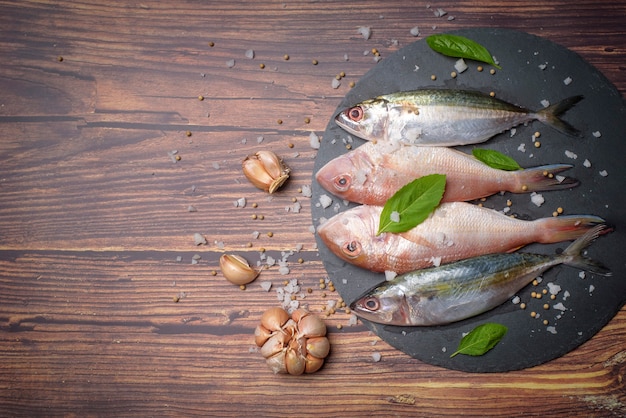 Pesce di mare fresco con garlics sulla superficie nera