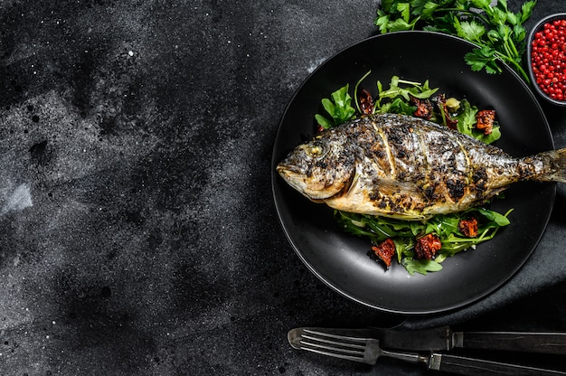 Pesce Dorado alla griglia con insalata di rucola e pomodori