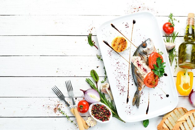 Pesce Dorado alla griglia con salsa e verdure su un piatto Vista dall'alto Spazio di copia gratuito