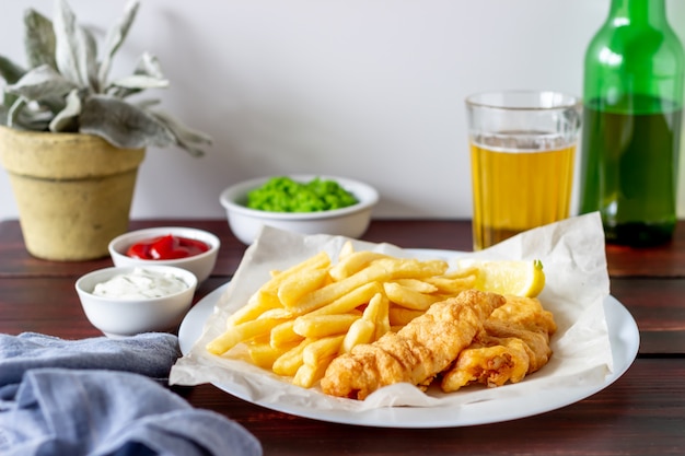 Pesce e patate fritte su un di legno. Fast food britannico. Ricette. Spuntino alla birra. Cucina inglese.