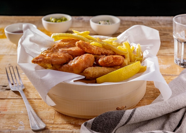 Pesce e patatine fritte in una ciotola con salse