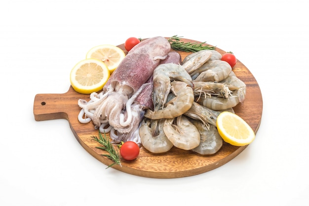 pesce fresco crudo (gamberetti, calamari) su tavola di legno