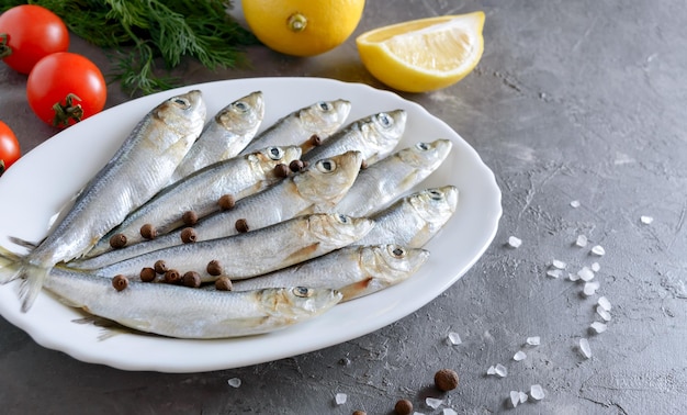 Pesce fresco di mare su un piatto su uno sfondo di cemento