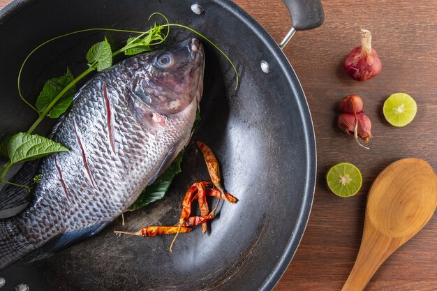 Pesce fresco in padella e spezie per cucinare