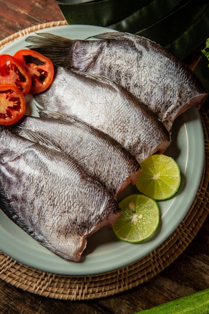 Pesce fresco in tavola guarnito con verdure