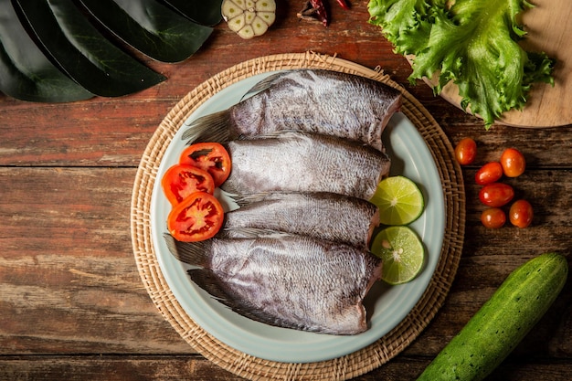 Pesce fresco in tavola guarnito con verdure