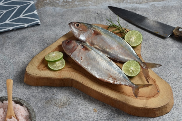 pesce fresco su tavola di legno con limerosmarino e sale himalaya