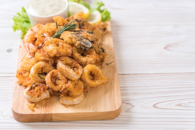 pesce fritto con salsa sulla tavola di legno