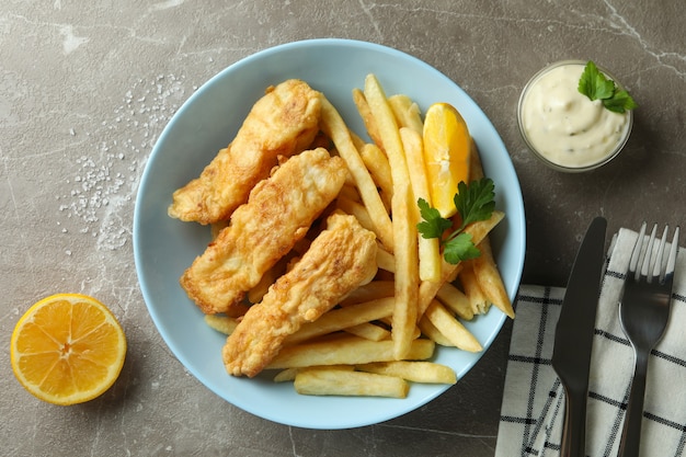 pesce fritto e patatine fritte sulla tabella strutturata grigia