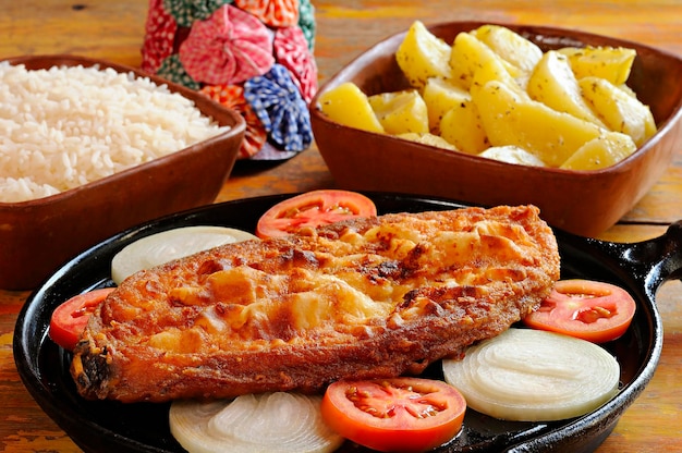 Pesce fritto in bistecca con cipolla e pomodoro con riso e patate Piatto del nord-est brasiliano