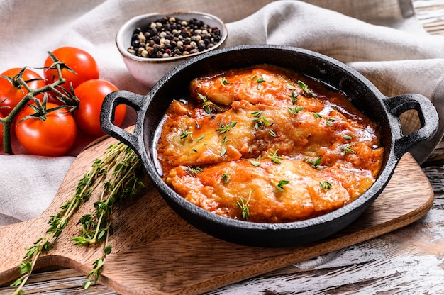 Pesce halibut al forno in padella con salsa di pomodoro