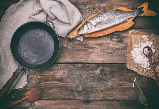 Pesce intero di branzino intero sul tagliere marrone