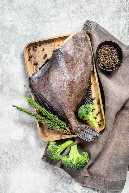 Pesce John Dory su un vassoio di legno con rosmarino e broccoli. Vista dall'alto