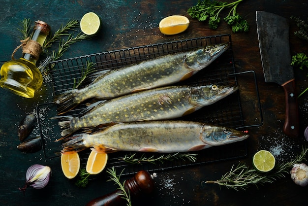 Pesce luccio con spezie ed erbe aromatiche Preparazione Su uno sfondo scuro della cucina Vista dall'alto