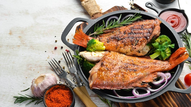 Pesce persico al forno con verdure su una lastra di pietra nera Vista dall'alto Spazio libero per il testo