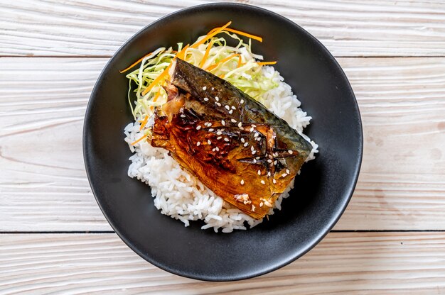 pesce saba grigliato con salsa teriyaki su ciotola di riso sormontata