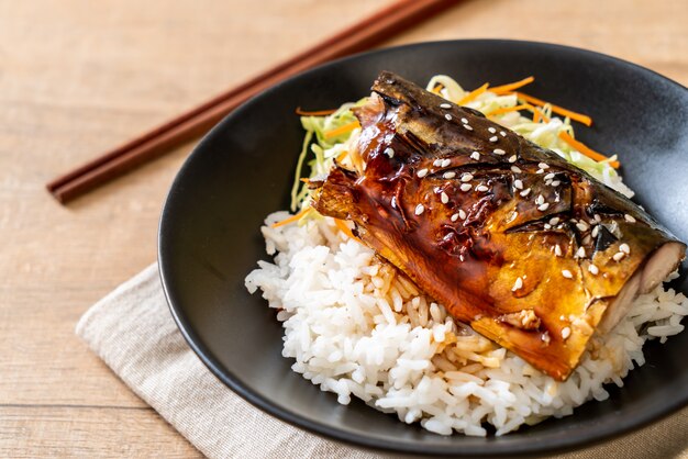 pesce saba grigliato con salsa teriyaki su ciotola di riso sormontata