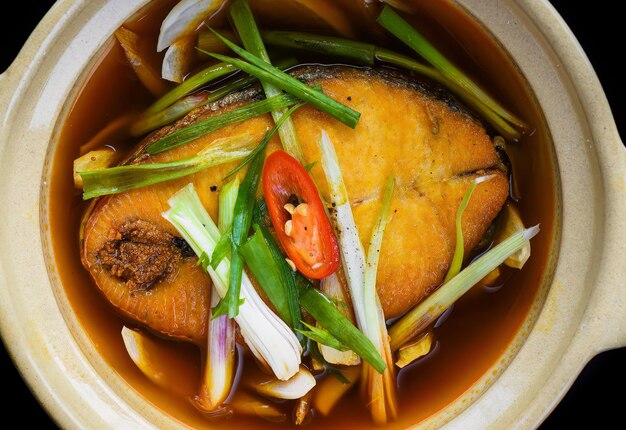 Pesce sapa stufato vietnamita in brodo isolato su bacground nero vista dall'alto