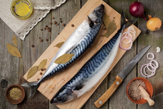 Pesce sgombro crudo con ingredienti su un vecchio fondo di legno