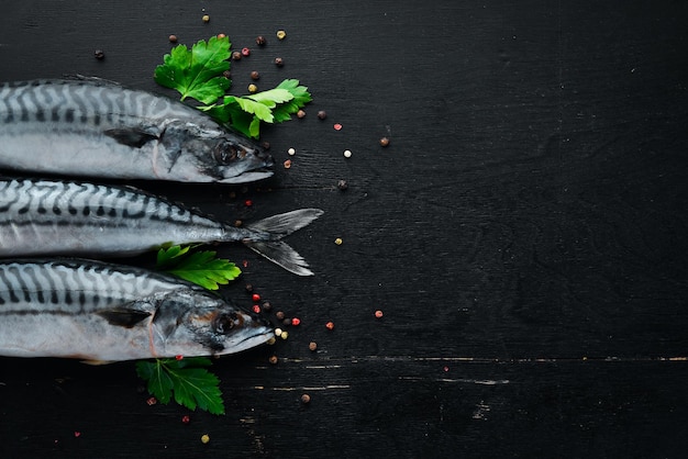 Pesce. Sgombro crudo su fondo di legno nero. Vista dall'alto. Spazio di copia gratuito.