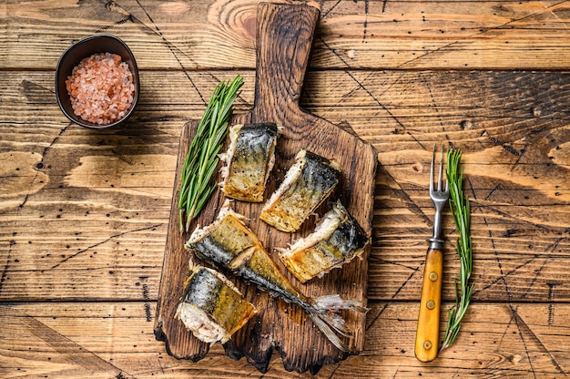 Pesce sgombro tagliato alla griglia sul tagliere. tavolo di legno. Vista dall'alto.