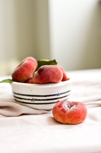 Pesche da dessert e bicchiere di vino su sfondo bianco minimo