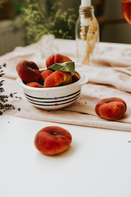 Pesche da dessert e bicchiere di vino su sfondo bianco minimo