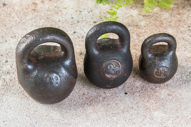 Pesi di ferro antichi per bilance su un tavolo di cemento