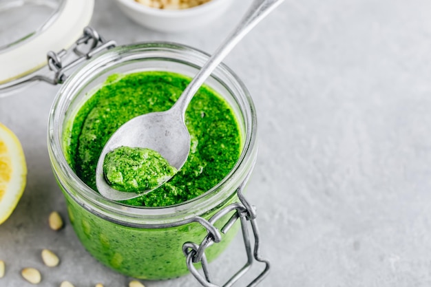 Pesto di basilico e pinoli fatto in casa in vasetto di vetro con parmigiano e olio d'oliva