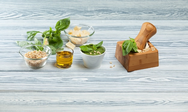 Pesto di basilico italiano tradizionale. Mortaio e ingredienti.