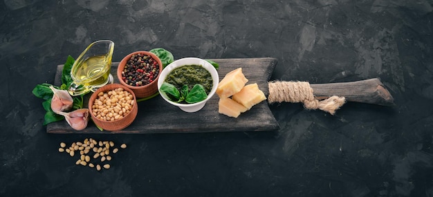 Pesto di basilico tradizionale Basilico parmigiano olio d'oliva pinoli pepe aglio Vista dall'alto Sul tavolo di pietra Spazio libero per il testo