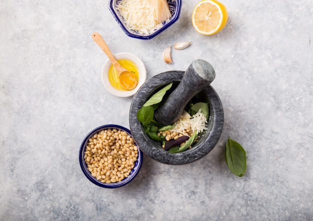 Pesto di basilico verde fresco con ingredienti in mortaio.