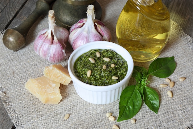 Pesto italiano e ingredienti su uno sfondo di legno scuro