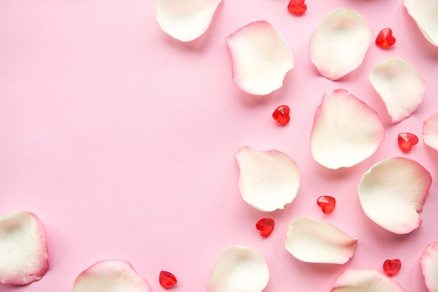 Petali di rosa bianchi e cuori su sfondo rosa Giorno di San Valentino o Giorno delle Madri sfondo astratto concetto d'amore Copia spazio per il testo