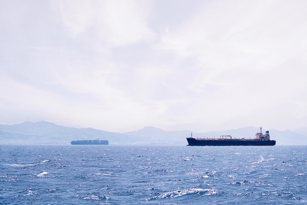 petroliera che naviga in riva al mare vicino a una nave da carico in una giornata di sole concetto di trasporto marittimo di petrolio e commercio di importazione ed esportazione