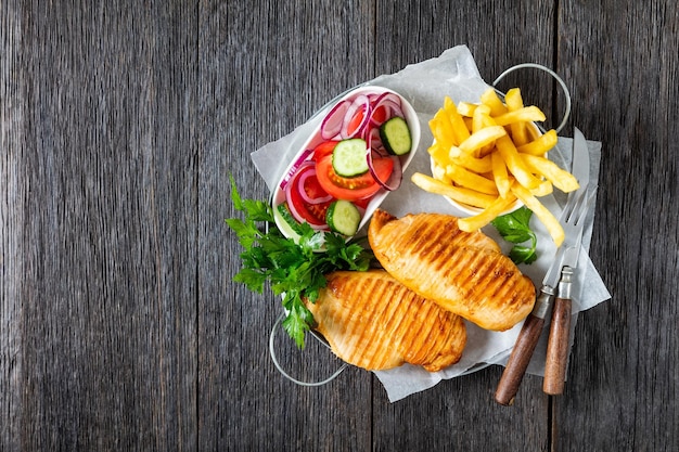 Petti di pollo con patatine fritte e insalata