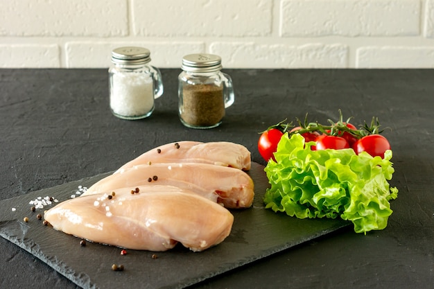 Petti di pollo crudi con prezzemolo e pomodori pronti per la cottura. cibo dietetico.