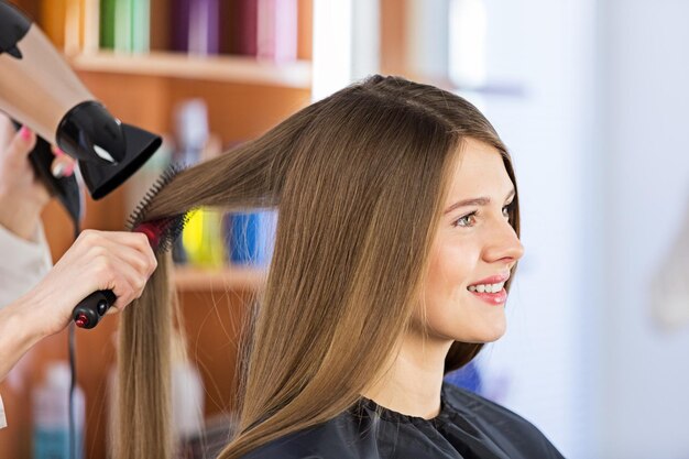 Pettinatura dello stilista della donna dell'asciugacapelli del salone di capelli