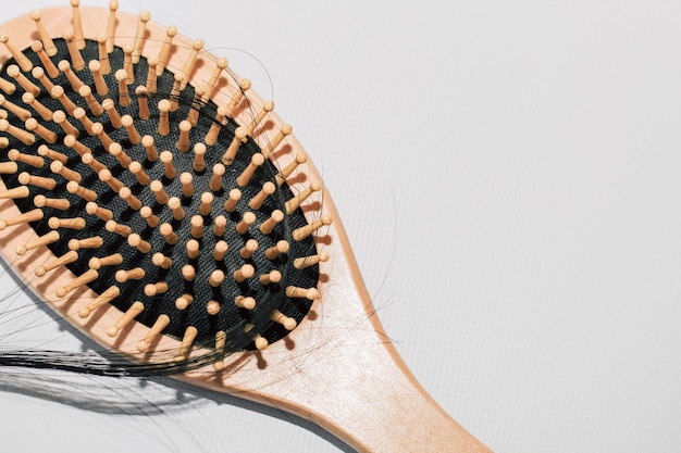 Pettine di legno con capelli caduti e forbici