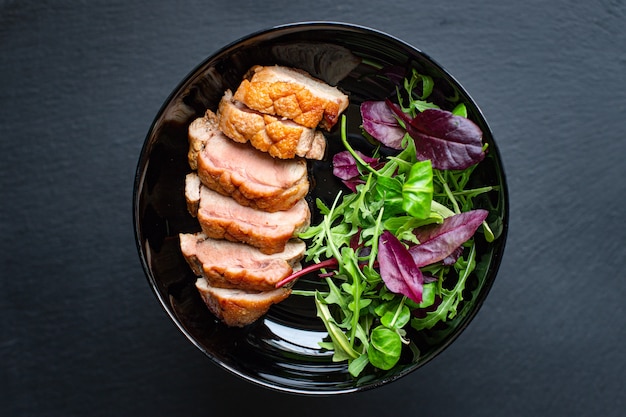 Petto d'anatra arrosto e foglie di insalata porzione di pollame di carne alla griglia o barbecue