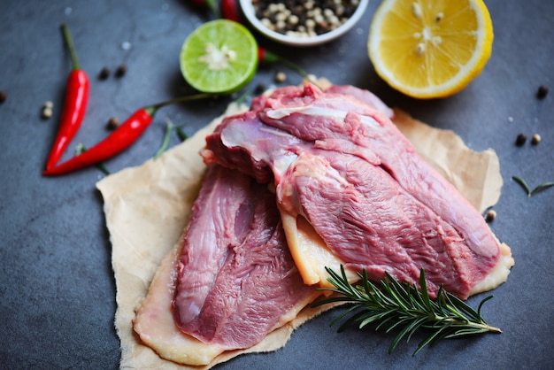 Petto d'anatra crudo con spezie alle erbe pronto da cucinare sul tagliere di legno, carne di anatra fresca per il cibo