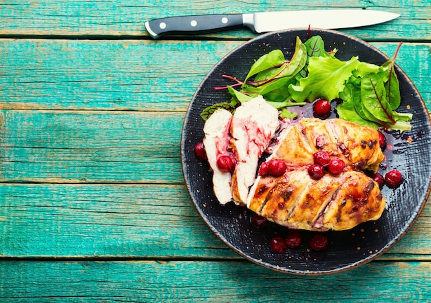 Petto di pollo al forno con ciliegie, affettato su un piatto. Copia spazio