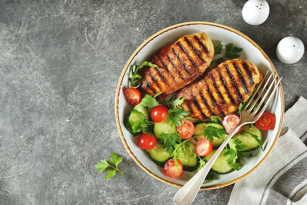 Petto di pollo alla griglia con insalata di pomodorini, cetrioli, rucola e prezzemolo