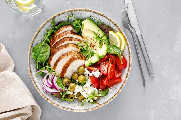 Petto di pollo alla griglia e insalata di verdure fresche con pomodori formaggio feta olive e avocado Cibo sano Vista dall'alto