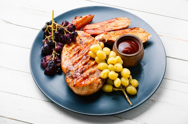 Petto di pollo arrosto con uva. Carne di pollo alla brace.