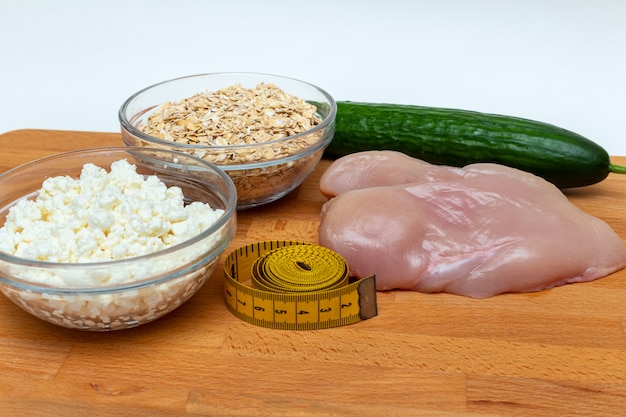 Petto di pollo, cereali, nastro di misurazione, fine della carota della ricotta dell'azienda agricola su. Dieta, concetto di cibo sano.