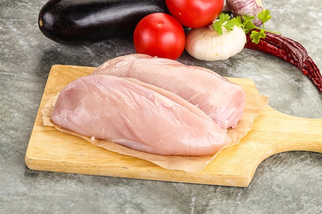 Petto di pollo crudo a bordo per cucinare