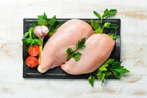 Petto di pollo crudo con prezzemolo e spezie sul tavolo Vista dall'alto Spazio libero per il testo Stile rustico